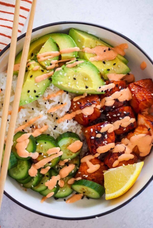 salmon avocado rice bowl with chop sticks.
