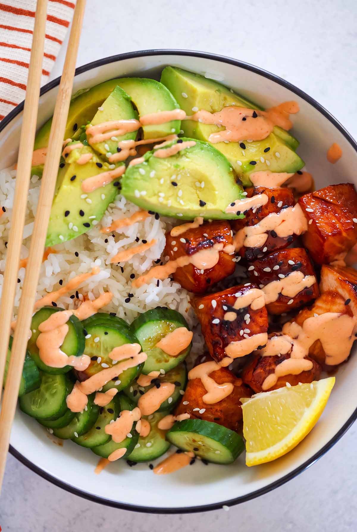 salmon avocado rice bowl with chopsticks.