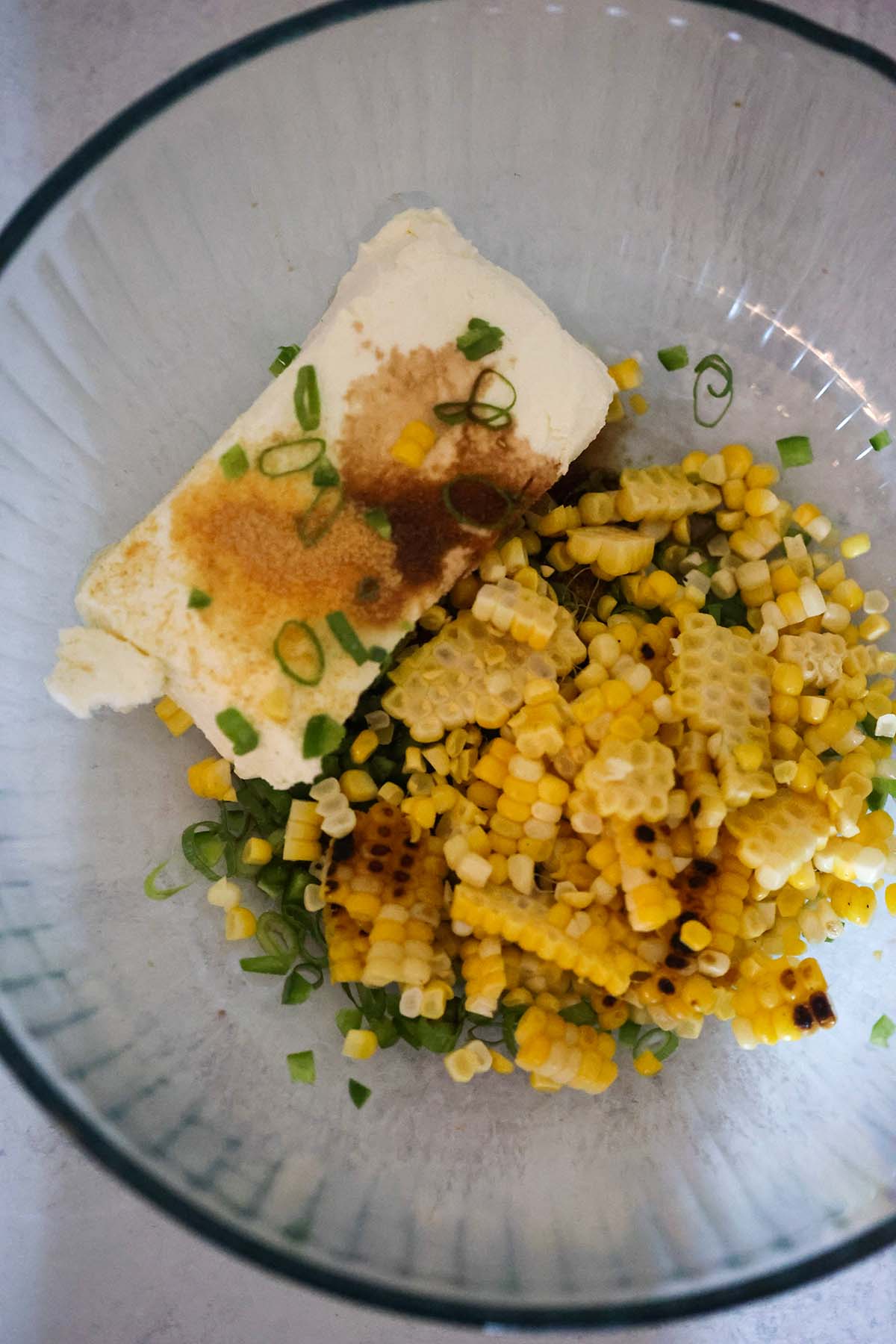 cream cheese, scallions, and corn in a bowl.