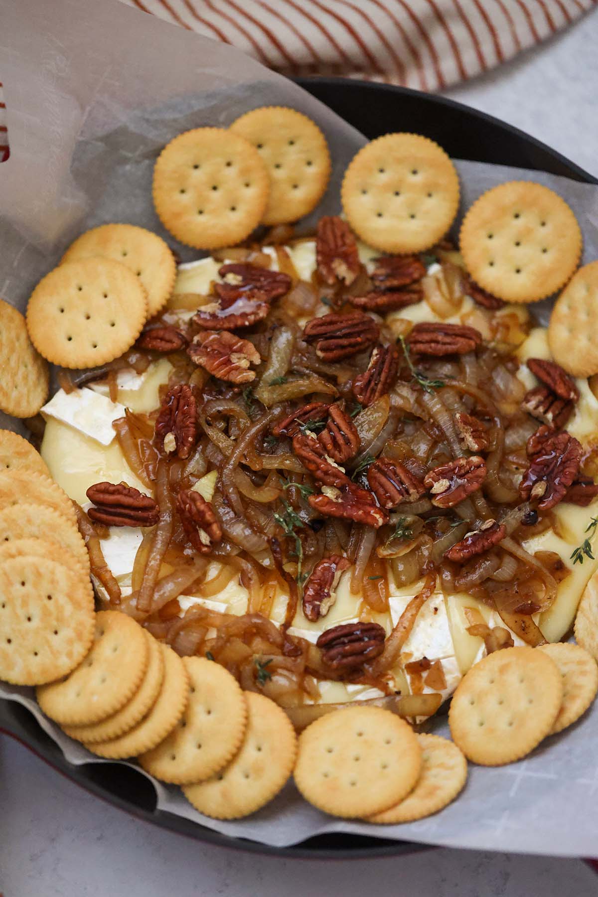 Baked brie with caramelized onions, pecans, honey, thyme, and Ritz crackers on the side. 