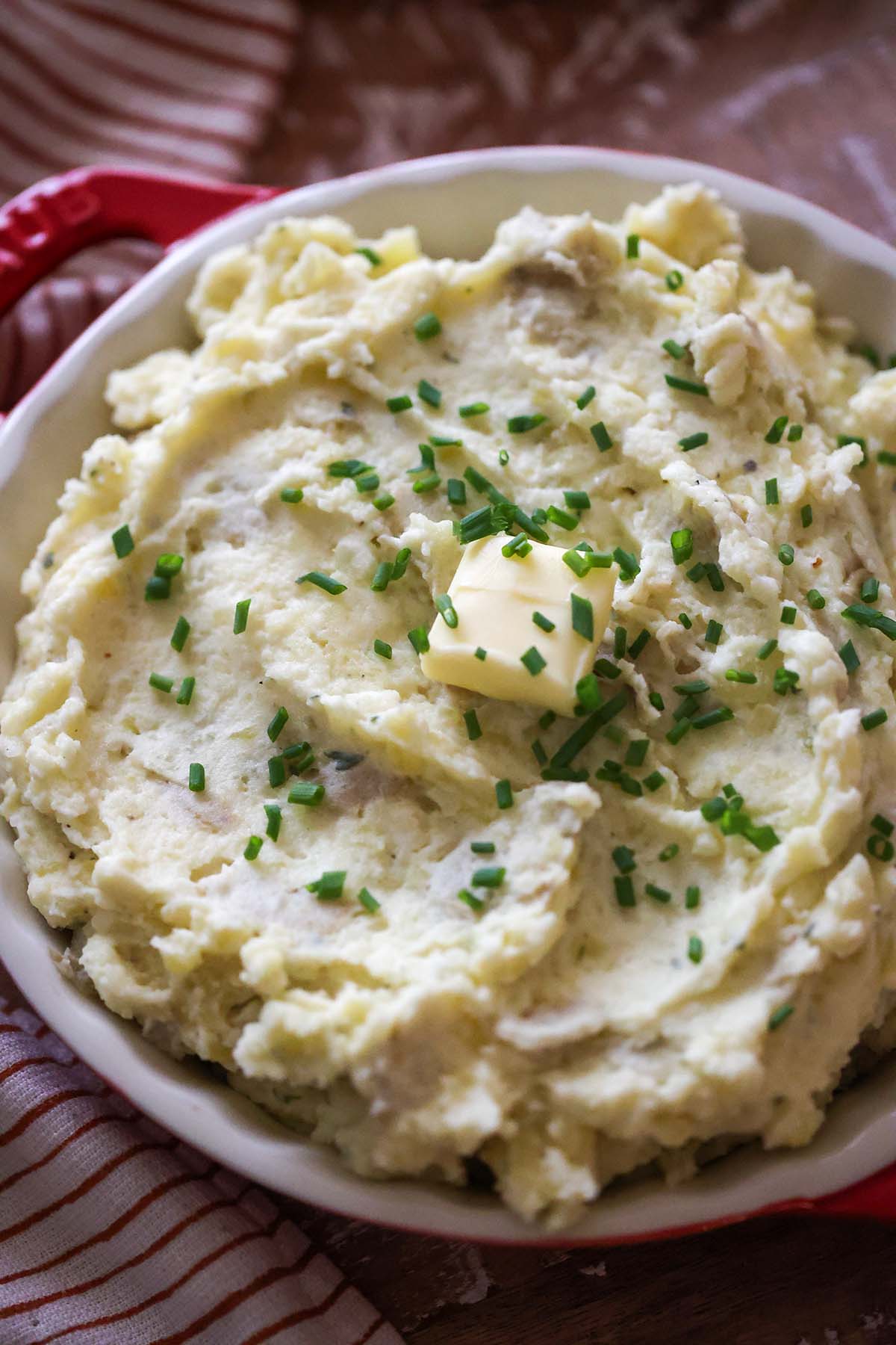 mashed potatoes in a red and white serving dish.