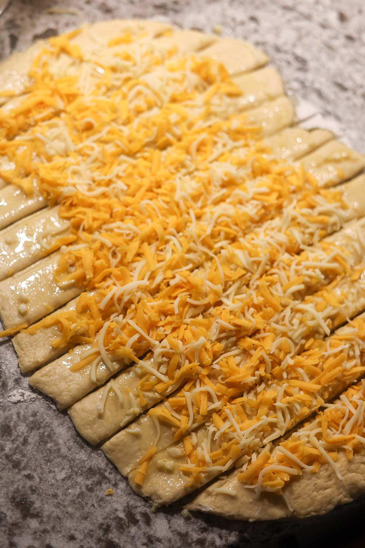 12 strips of dough with cheese on top.