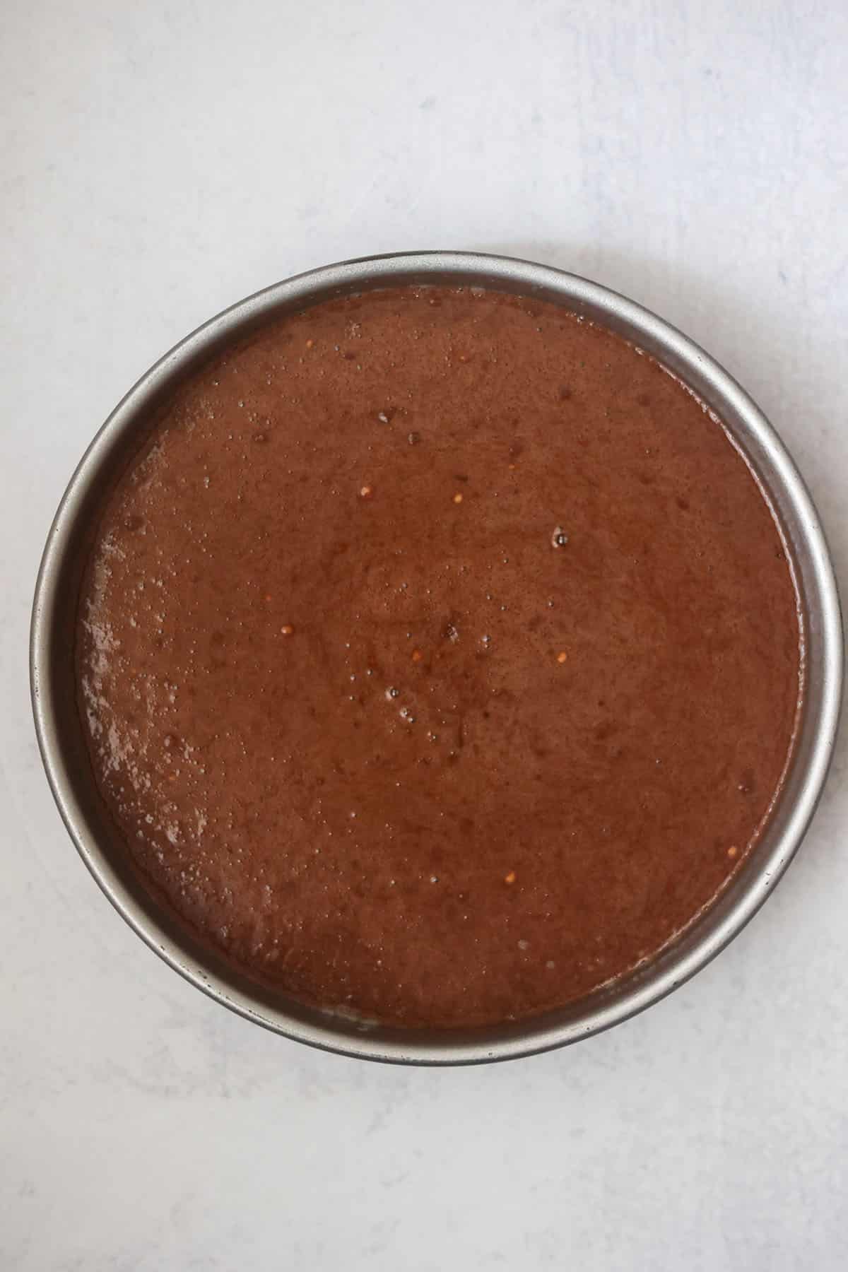chocolate cake batter in a 9-inch cake pan.
