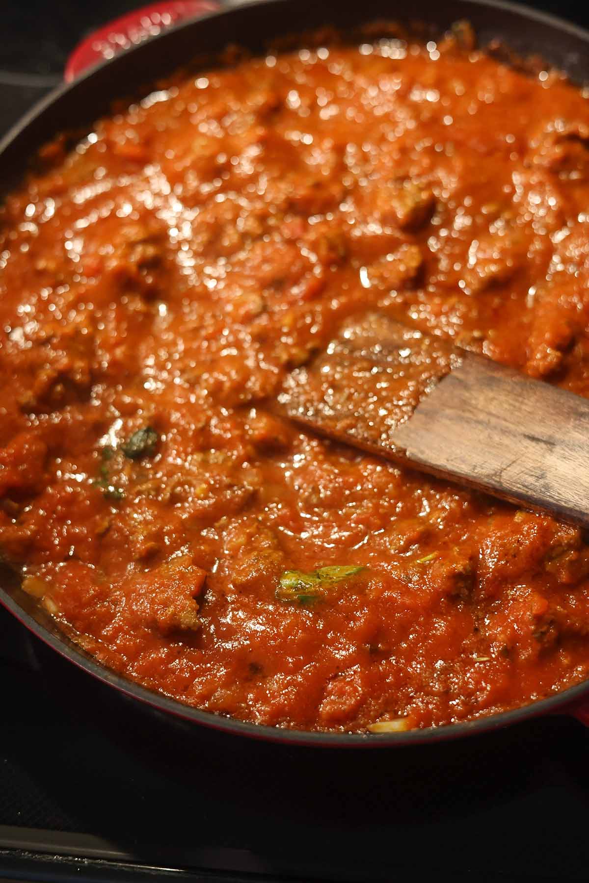 meat sauce cooking in a skillet on the stovetop.