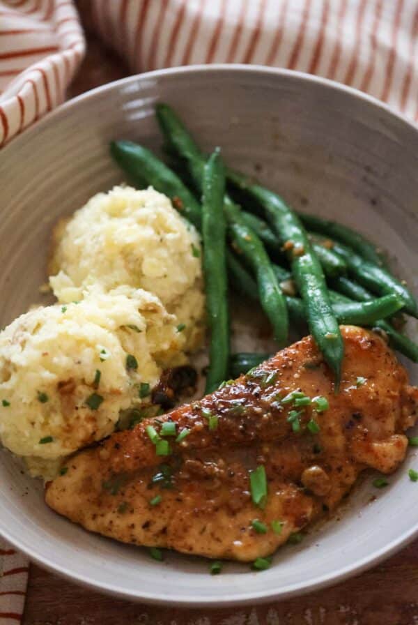 lemon butter chicken with mashed potatoes and green beans.